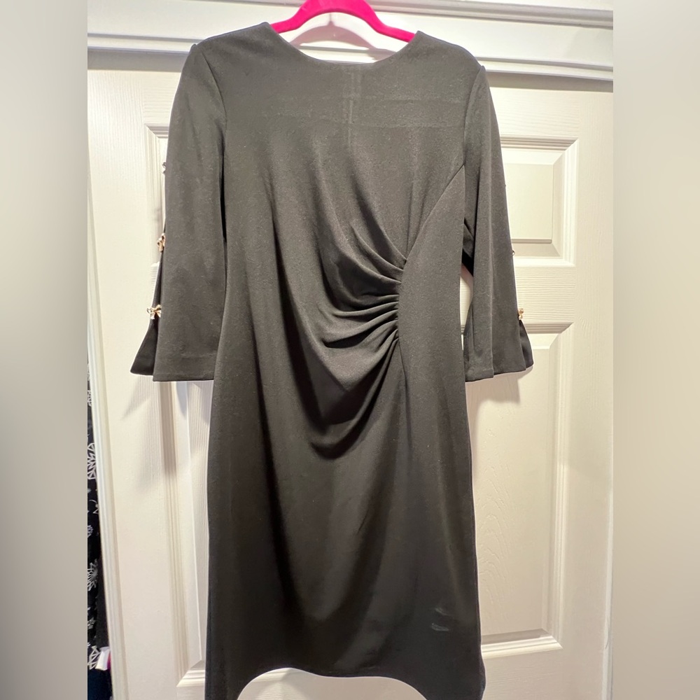 Women’s flattering black dress with open, cut out sleeve with bow embellishments